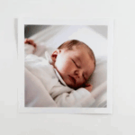 Retro Prints with Wooden Box - photo 3 A sleeping baby wrapped in a white blanket, with eyes closed and cozy expression.