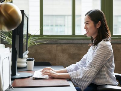 Chinese woman working at a computer in an office, side view